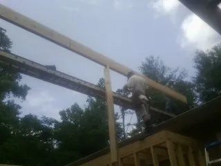 Carpenter setting a ridge beam over a new addition frame — Ice Dam Removal by Roofing Brothers in Marengo