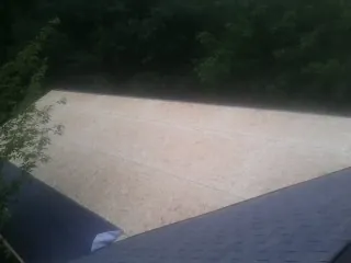 New OSB roof sheathing installed beside an existing shingle roof in Marengo