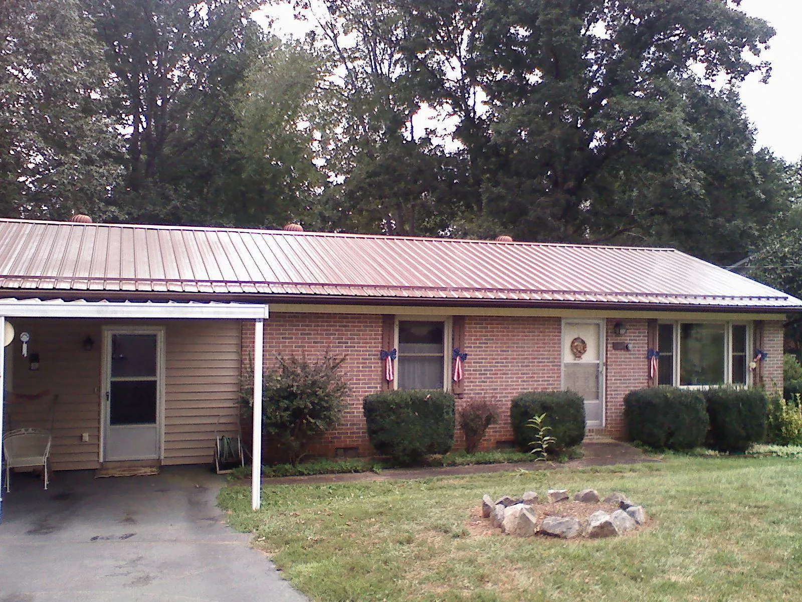 Bronze metal roof and carport on a brick ranch home — Roof Repair work by our crew in Marengo